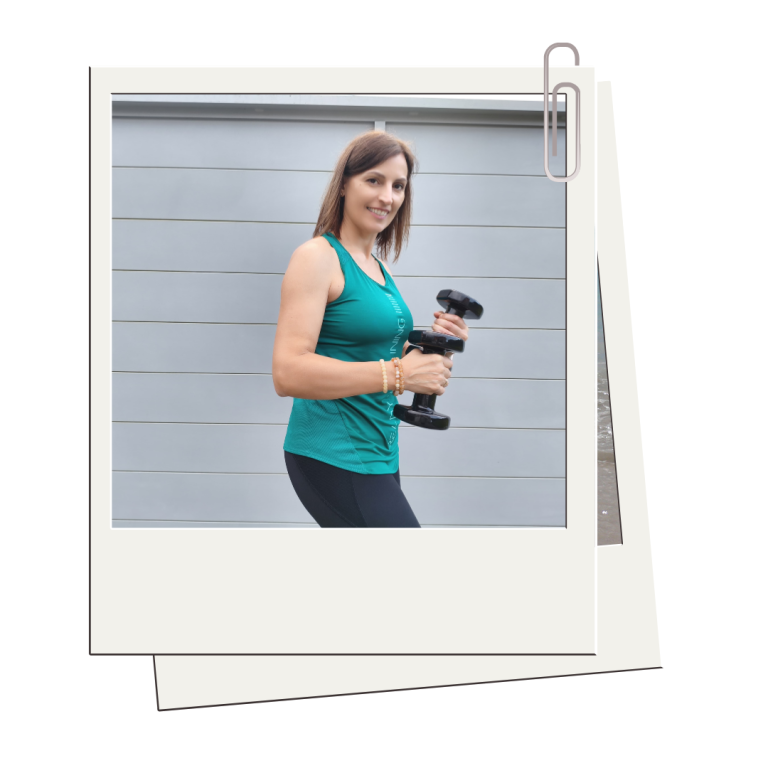 Mujer con ropa deportiva verde y negra sosteniendo pesas pequeñas mientras sonríe, con un fondo gris moderno.